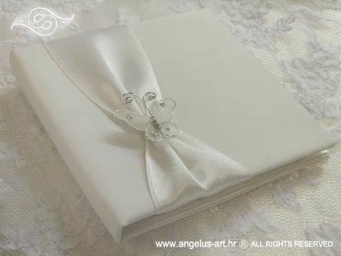 bijela knjiga kao jastučić za prstenje s bijelim leptirom