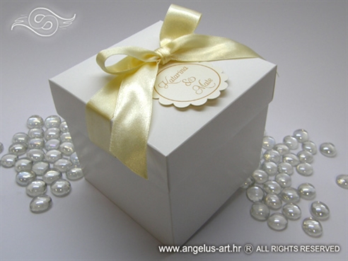 bijela kutija za kolače s krem mašnom i ukrasnim kartončićem